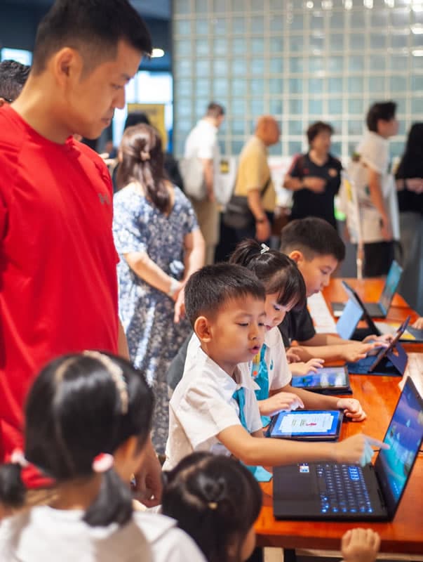 Children working through a coding activity on tablets