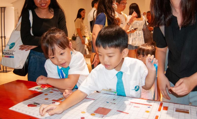 Children exploring an Unplugged Coding board game together